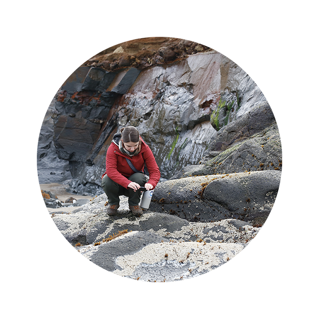Picture of Eva kneeling to take a picture in a tidepool